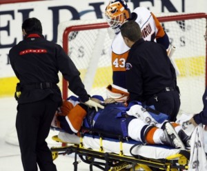 New York Islander's Kyle Okposos is carried off on a stretcher after being hit by Calgary Flame's Dion Phaneuf.
